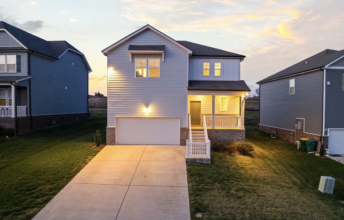 138 Millbrook Drive at dusk, a two-storey home with covered porch and two-car garage